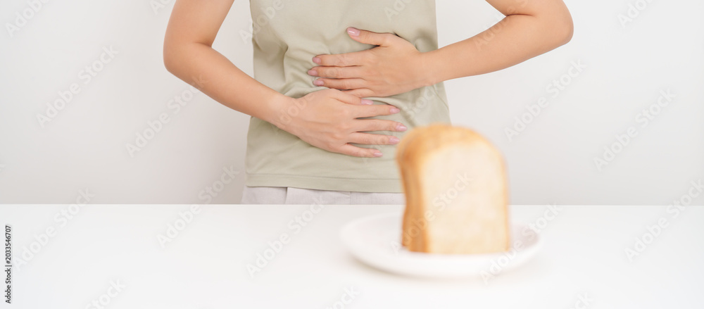 Obraz premium Gluten intolerance, Gluten free and celiac disease or Wheat allergy. woman with wheat bread and having abdominal pain after eat gluten. stomach ache, Nausea, Bloating, Gas, Diarrhea and Skin rash