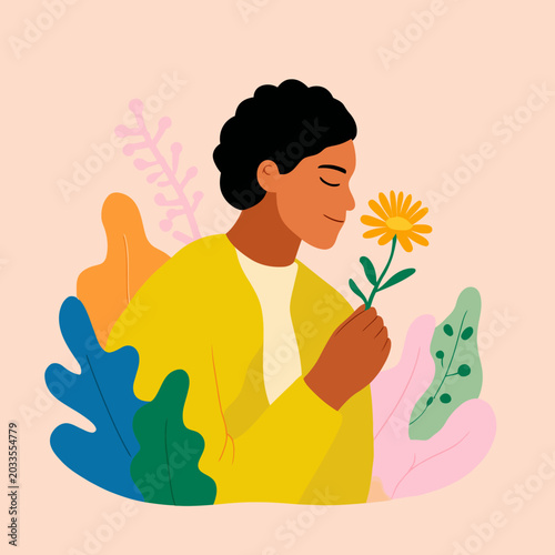 Person smelling yellow flower with closed eyes