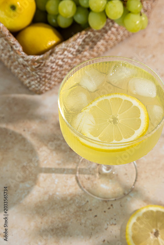 Summer alcoholic drink, Lemon Spritz or Limoncello in a glass on a table with lemons