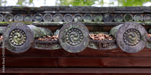 Detail of decorative roof end tiles with tomoe spiral pattern on Japanese temple, Kyoto, Japan