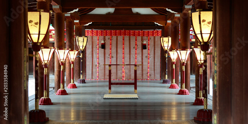 Interior of main hall with illuminated lanterns and ceremonial curtain at Kamigamo shrine, Kyoto, Japan