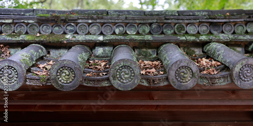 Detail of decorative roof end tiles with tomoe spiral pattern on Japanese temple, Kyoto, Japan