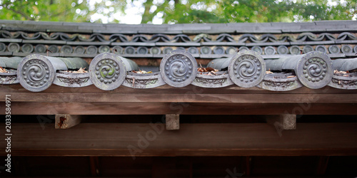 Detail of decorative roof end tiles with tomoe spiral pattern on Japanese temple, Kyoto, Japan