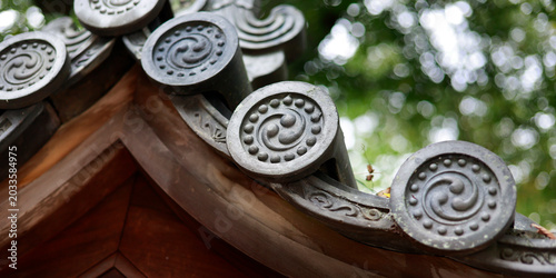 Detail of decorative roof end tiles with tomoe spiral pattern on Japanese temple, Kyoto, Japan