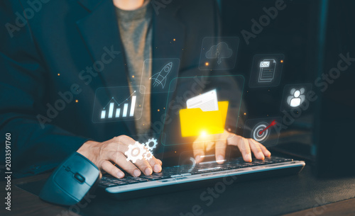 Document management system (DMS) and cloud storage concept. Businessman using laptop for digital file organization, online database infrastructure, and corporate data security.