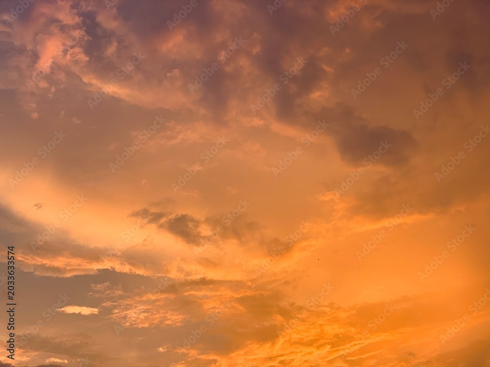 Fototapeta premium Cinematic orange sunset clouds with dramatic pastel sky and soft texture, captured in wide-angle focus. Perfect for luxury branding, wellness ads, travel banners and aesthetic wallpapers.