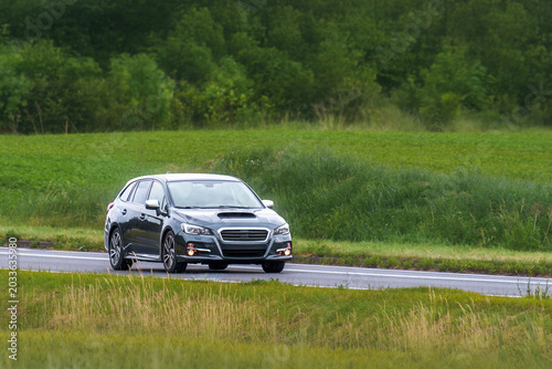 Fotografi Driving a comfortable station wagon on a country route