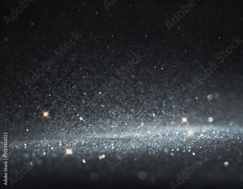 Glowing particles sparkle in the dark space environment with a streak of light.