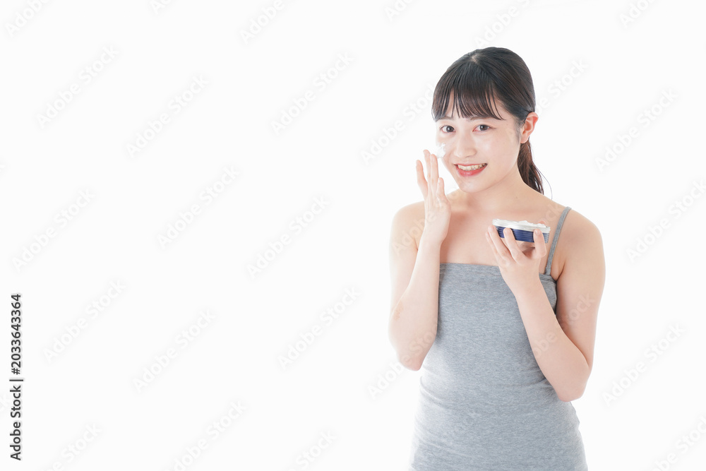 Fototapeta premium 顔にクリームを塗る若い女性