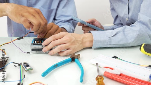 Close-up, Hand man and woman connecting soil moisture sensors to microcontroller