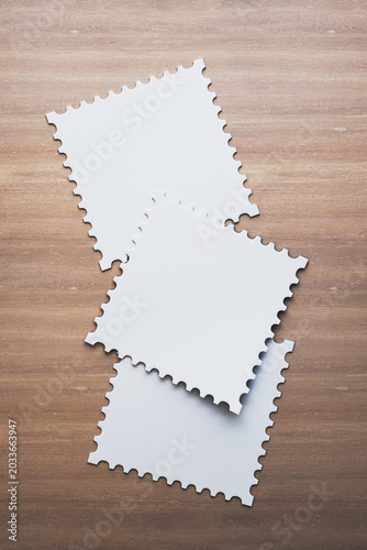 Blank postage-style square stickers mockup arranged on wooden tabletop backgr...