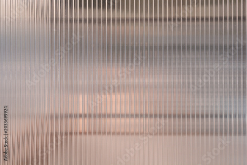 Canvastavla A full frame view shows the surface of a semi transparent ribbed glass panel with vertical textured lines and a soft brown background showing through