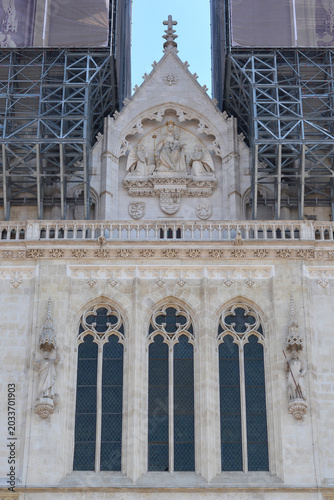 Valokuva Front close up view of the stone facade of Zagreb Cathedral featuring arched gothic windows and a decorative relief tympanum with construction scaffolding