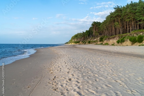 Photography Pristine white sandy beach in Dziwnówek, Poland, with untouched coastline, soft dunes, and calm Baltic Sea under a clear summer sky