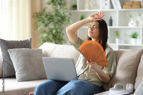 Foto Young student suffering heat stroke fanning at home