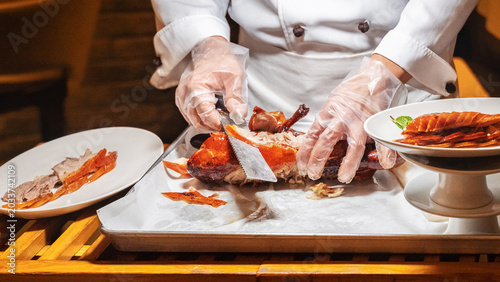 Photos Chef prepares Peking duck dish in restaurant with careful slicing and presentati