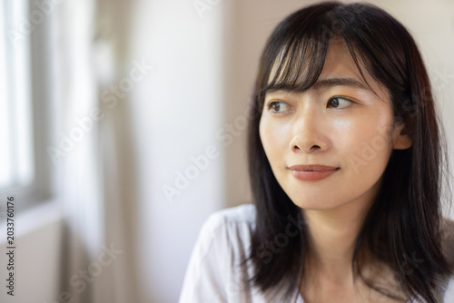 Foto Young Asian woman gazing out of window
