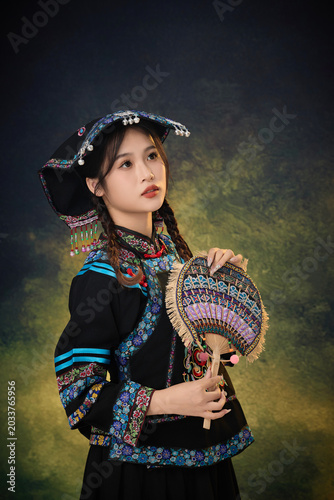 Принти на полотні Young Asian Woman in Traditional Ethnic Costume Holding Embroidered Fan