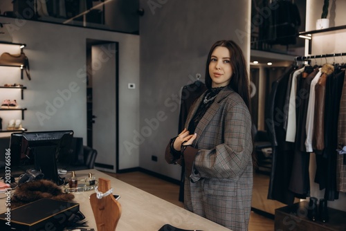 Photos Stylish woman trying on plaid blazer in fashion boutique