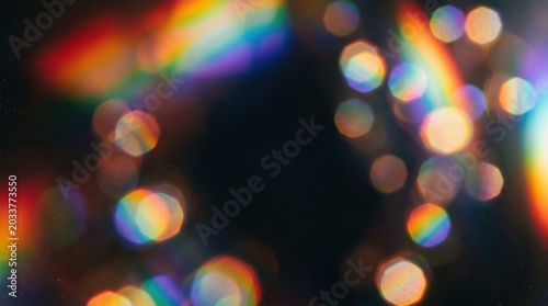 Blur colorful rainbow prism light leaks on black background, retro lens flare overlay for posters, music visuals, branding and cinematic design, glowing multicolored bokeh with analog mood, layered