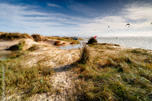Fotografie Spanish coast with dunes and kites on a sunny day, Tarifa.
