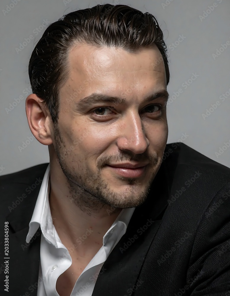 Fototapeta premium Professional businessman with short dark hair and beard in formal attire.