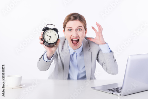 Tableau sur toile Stressed Businesswoman Holding Alarm Clock at Desk
