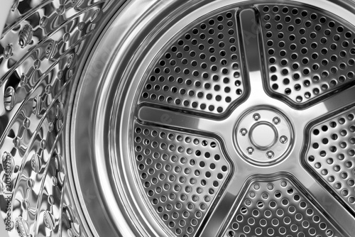 Reflective perforated metal surface inside a contemporary washing machine drum