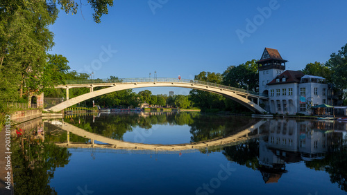 Foto Arched pedestrian bridge reflected in a calm river