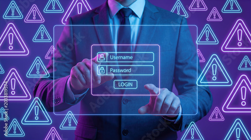 Businessman pressing login button on virtual interface with username and password fields surrounded by warning signs. Cyber security alert, phishing attack, data breach, hacker threat and online fraud