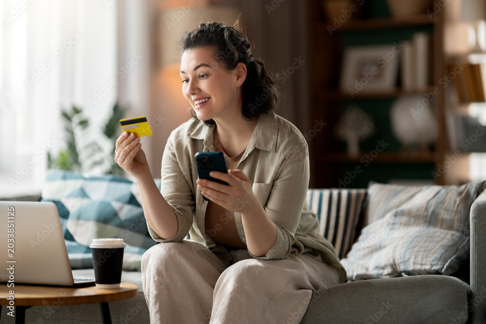 Obraz premium Happy Woman Shopping Online with Credit Card and Smartphone at H