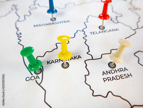 Close-up map of southern India with a yellow push pin marking Karnataka. Adjacent states like Goa, Andhra Pradesh, Telangana, and Maharashtra are highlighted with vibrant, colorful markers.