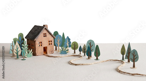 Clay miniature house with paper trees in landscape isolated on transparent