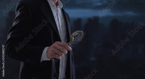 Professional businessman holding magnifying glass in dark office with city background, symbolizing investigation, business analysis, corporate audit, cybersecurity, research, and strategic inspection.