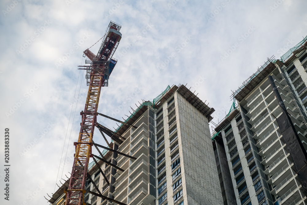 Fototapeta premium Tower Crane and High Rise Building Construction Against Blue Sky