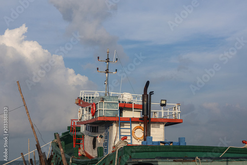 Foto Bridge and upper deck of a traditional commercial wooden fishing boat under a cl
