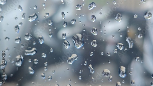 Bild auf Leinwand Clear water droplets on a transparent window glass pane surface with soft blurred background, creating a calm abstract texture during rainy day