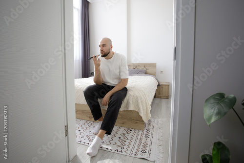Man dictates a voice message on a smartphone at home