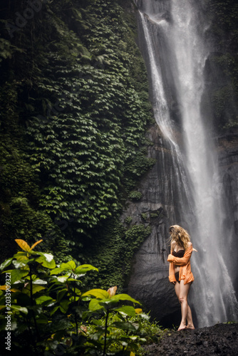 Tableau sur toile A beautiful girl against the backdrop of a waterfall and zenene on a tropical is