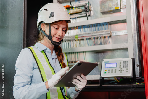 Industry Electrician, Engineer electricity technician woman check electric wire at industry machine.
