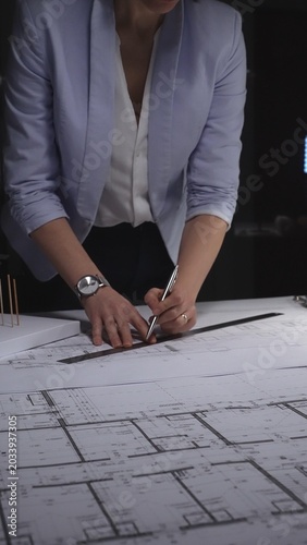 Cuadro en lienzo Architect drawing on construction plans, developing a new building design with a ruler and pen on paper
