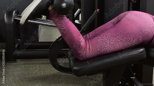 Elderly woman exercising on gym equipment in colorful workout leggings  