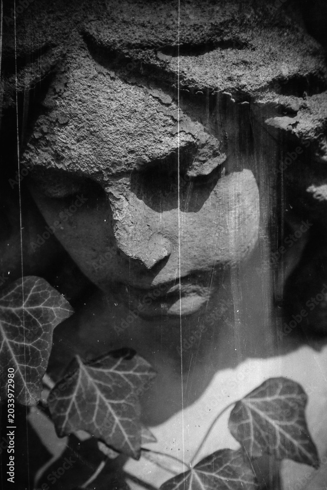 Obraz premium Sad angel statue symbolizing grief, death and emotional pain.