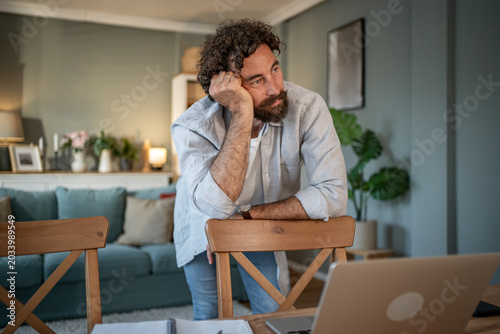 Foto Man thinking about work procrastinating at home