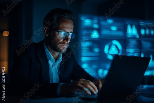 Professional Man Working on Laptop with Warning Signs and Data Visualization in Background for Cybersecurity and Technology Themes