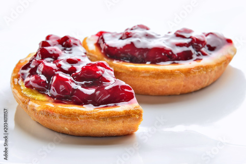 Round cherry cake with fruit jelly and fresh cream on white table