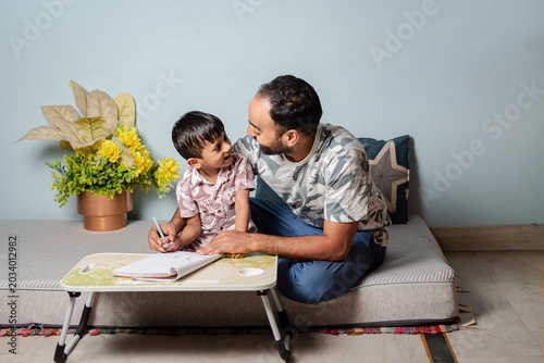 Father Teaching Son To Write At Home, Educational Support And Family Bonding