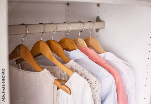 Fotografie White shirts on hangers in closet, orderly display