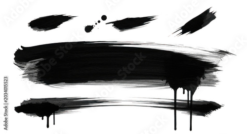 Collection of black and white ink brush strokes, dry paint textures, and dripping liquid splatters isolated on a solid black background