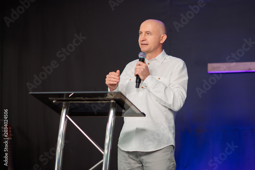 Tablou pe pânză Christian pastor speaking at transparent podium during church worship cross back